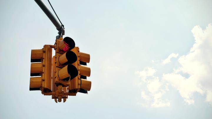 a cropped image of a stop light against a clear blue sky