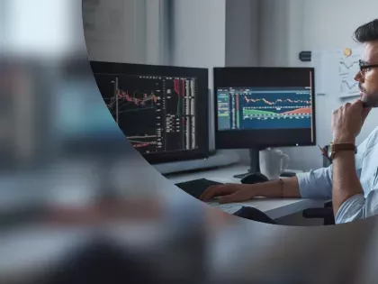 a man sits at his desk reading reports on several monitors to help detect shadow it